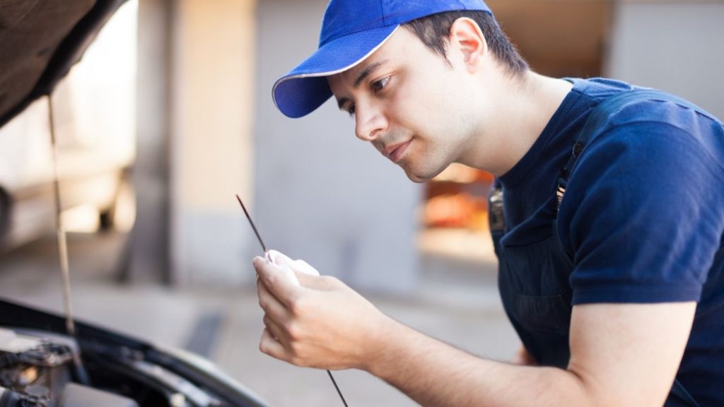 Man checking the dipstick of the engine 