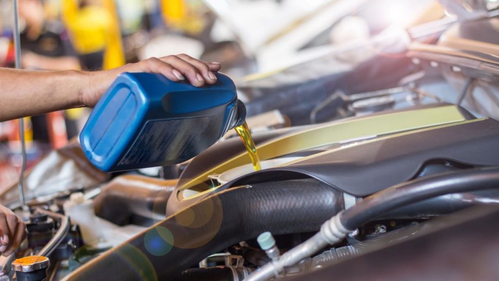 Man pouring a bottle of motor oil