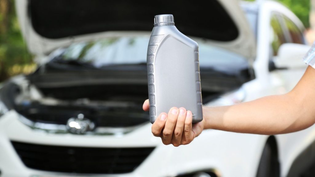 Man holding a bottle of synthetic oil