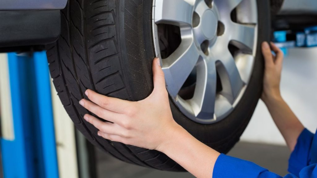 A person checking the tire pressure and alignment