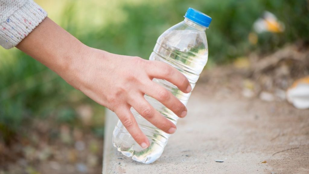 A person holding a plastic water bottle
