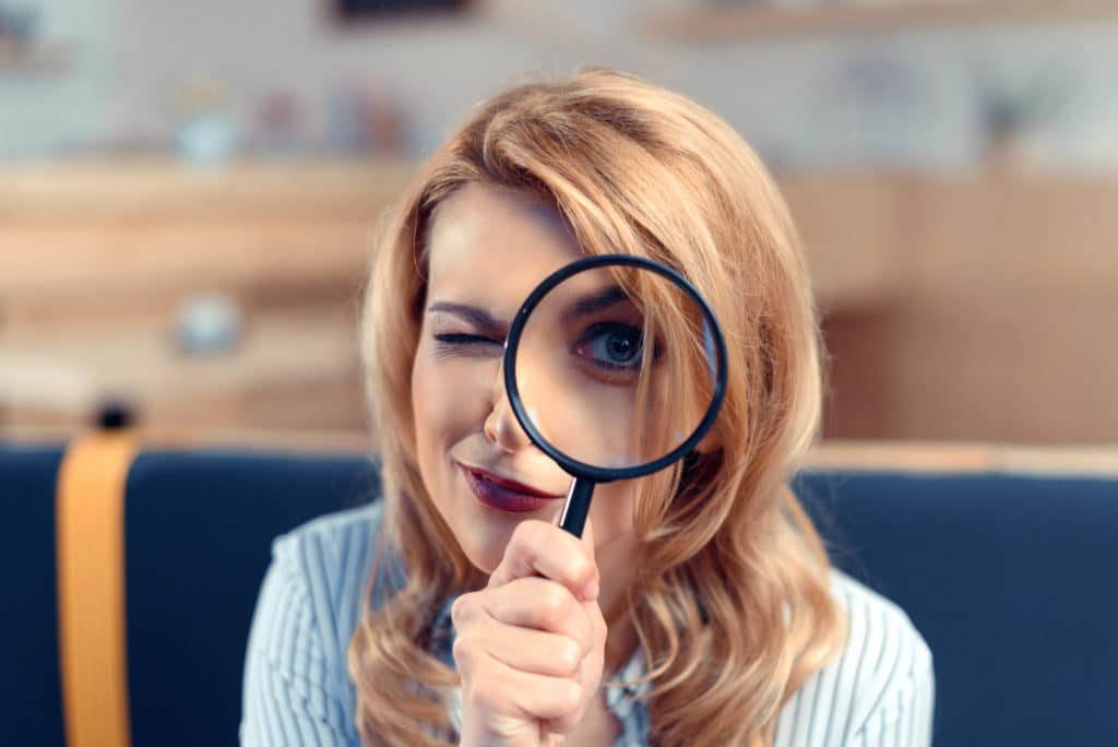 woman using magnifying lense