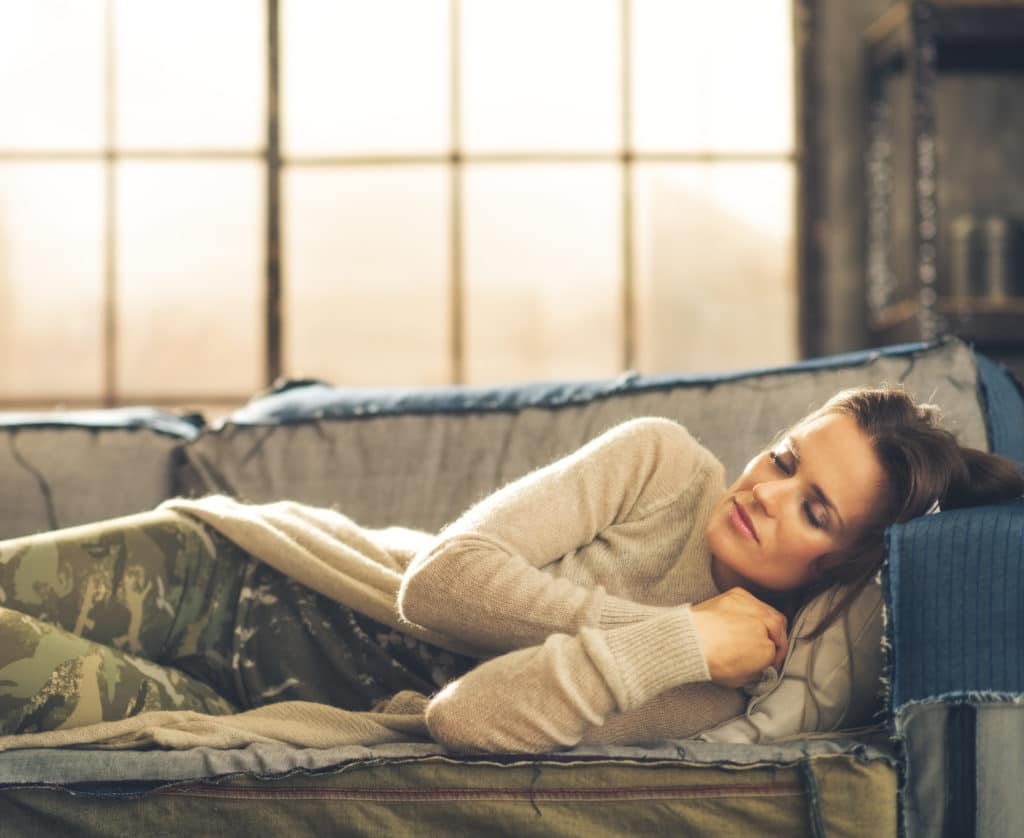 Woman Napping On A Sofa In A City Loft