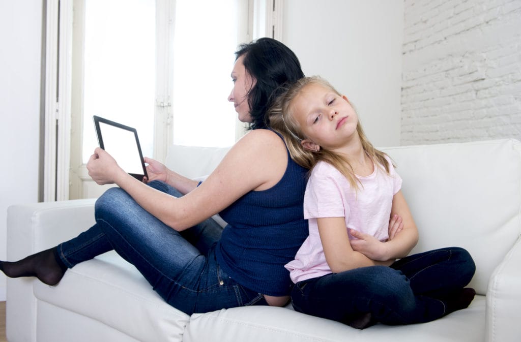 internet network addict mother using digital tablet pad ignoring little sad daughter left alone bored