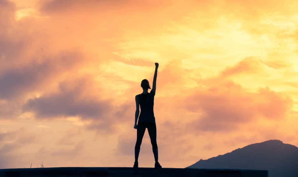 Stand,strong.,woman,with,fist,in,the,air.,feeling,motivated,