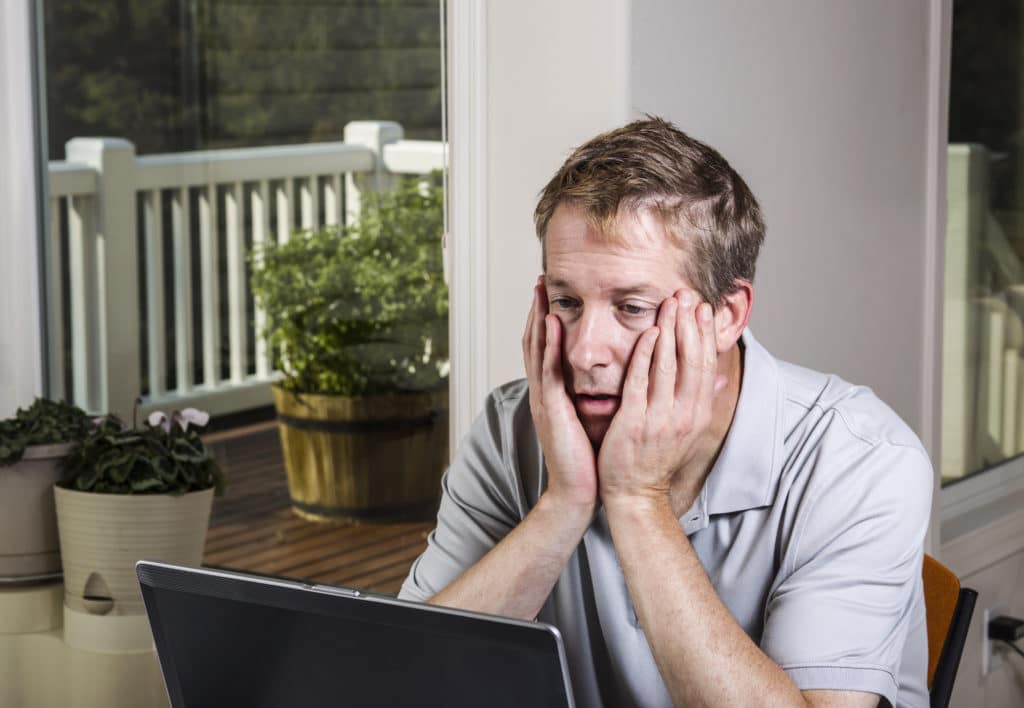 Tired,man,looking,at,data,results,on,computer,at,home