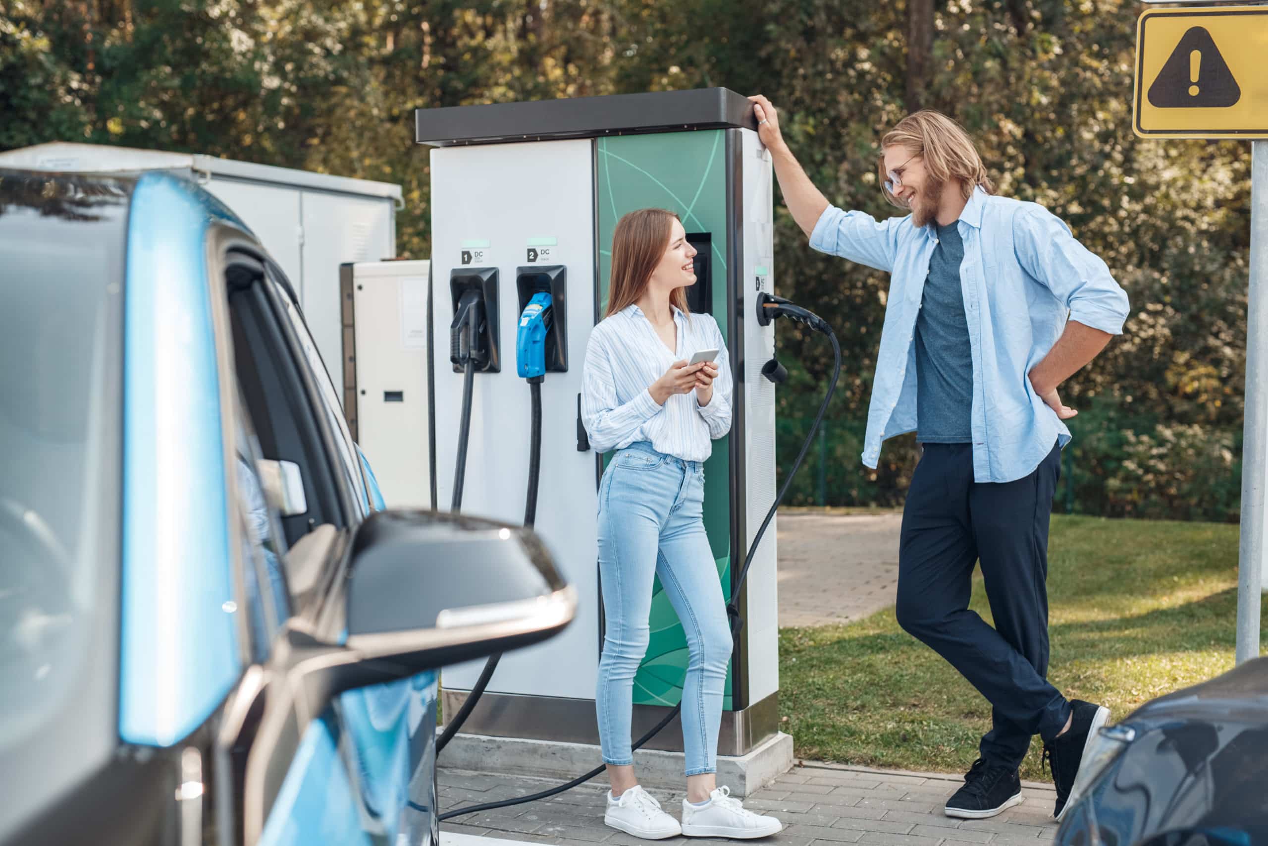 Young,couple,man,and,woman,traveling,by,electric,car,having