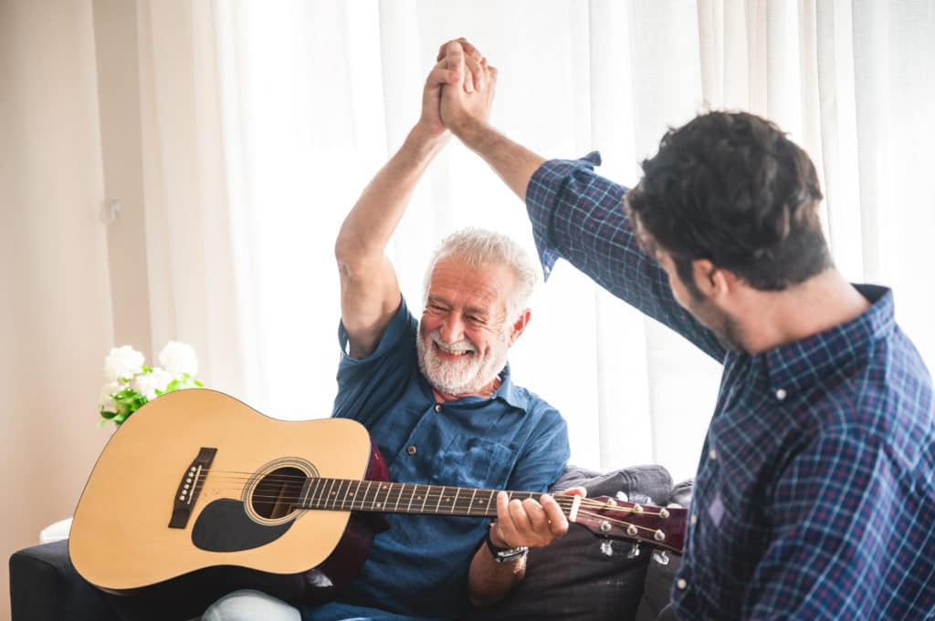 Elderly,dad,and,son,are,playing,music,at,home,,relax