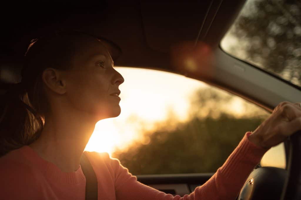 Young,woman,driving car at,sunrise,,sunset