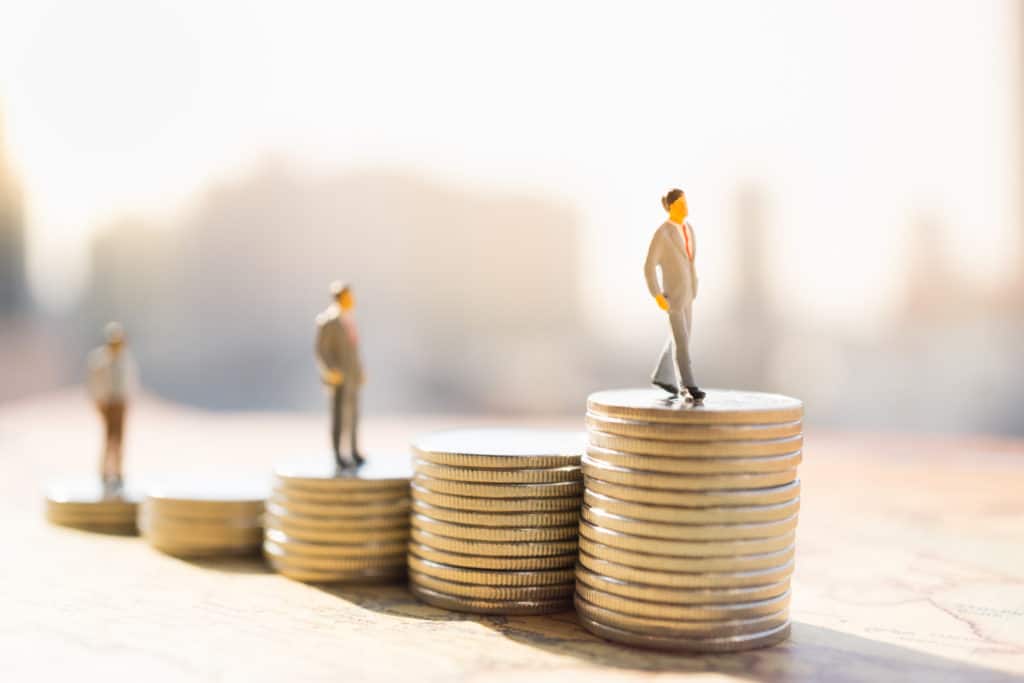 Miniature,people:,small,figure,standing,on,stack,of,coin.,money