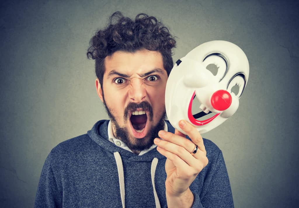 Portrait Young Upset Angry Screaming Man Holding A Clown Mask