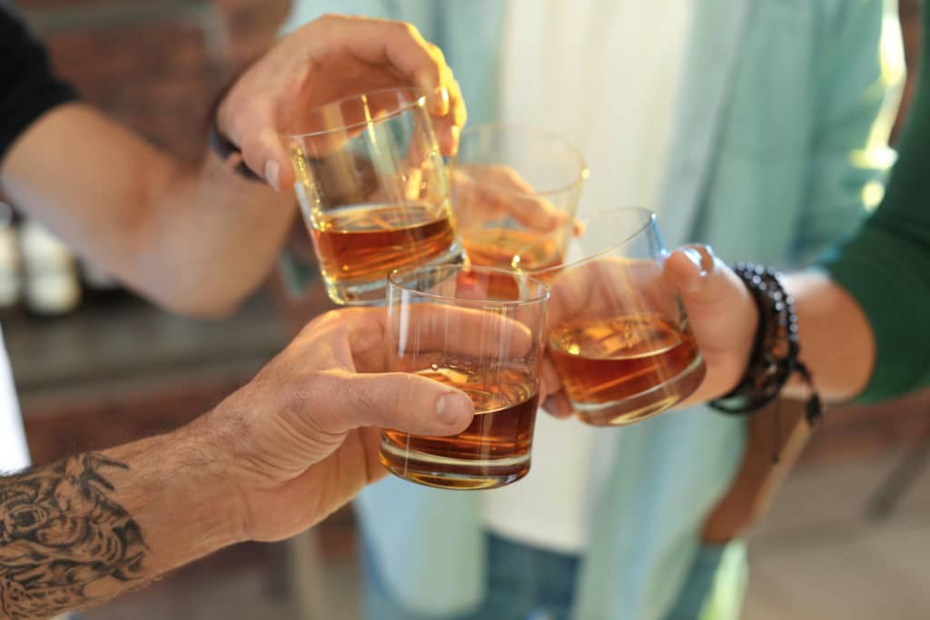 Friends Toasting With Glasses Of Whiskey Indoors Closeup