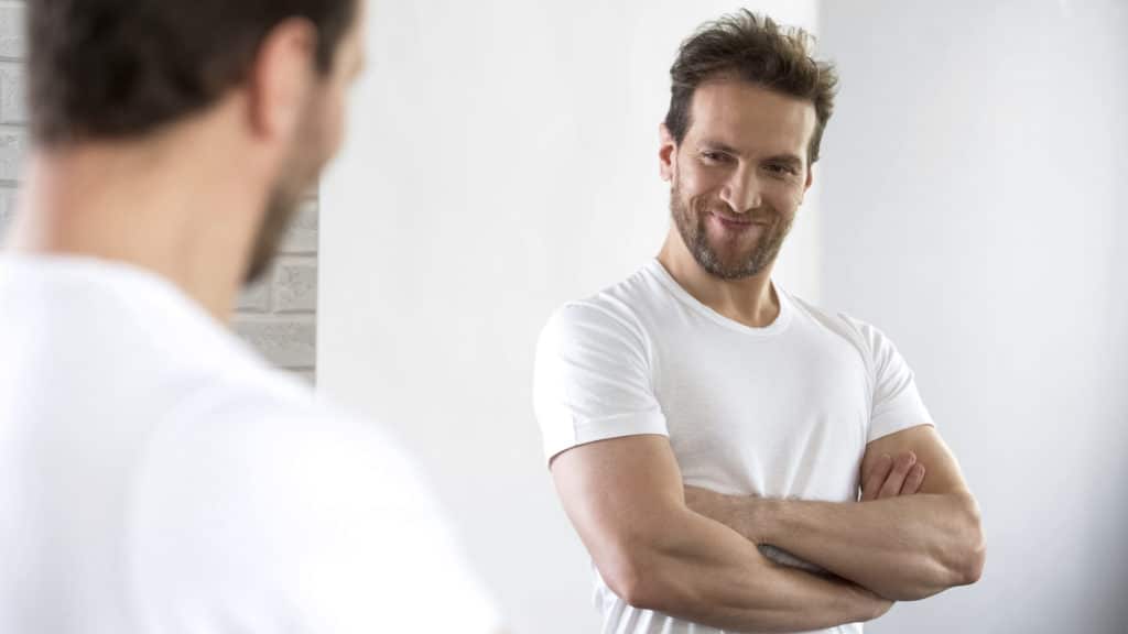 Satisfied With Beautiful Sports Figure Male Examining His Reflection In