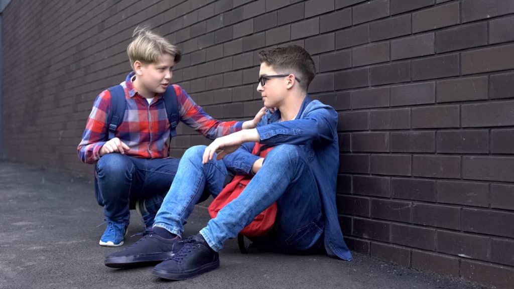 Kind Teenage Boy Starting Friendship With Bullied Student Helpline For