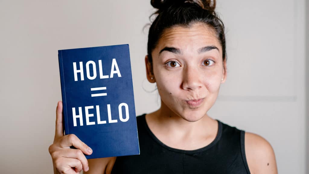 Portrait Of Woman Holding Book With The Words "hola =