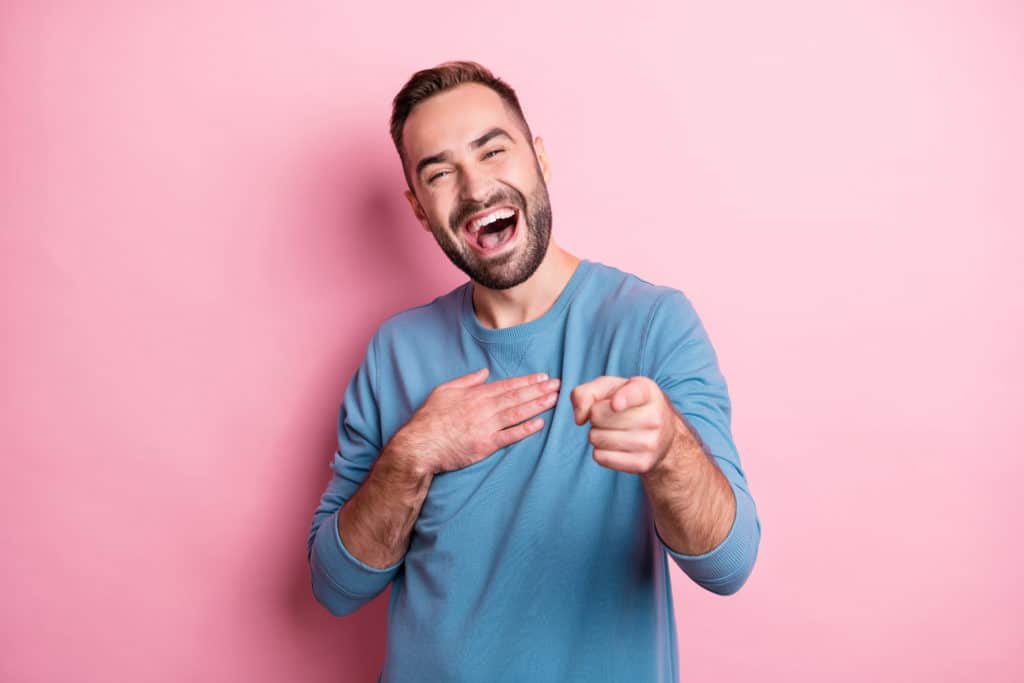 Photo Of Charming Young Man Dressed Blue Sweater Laughing Arm