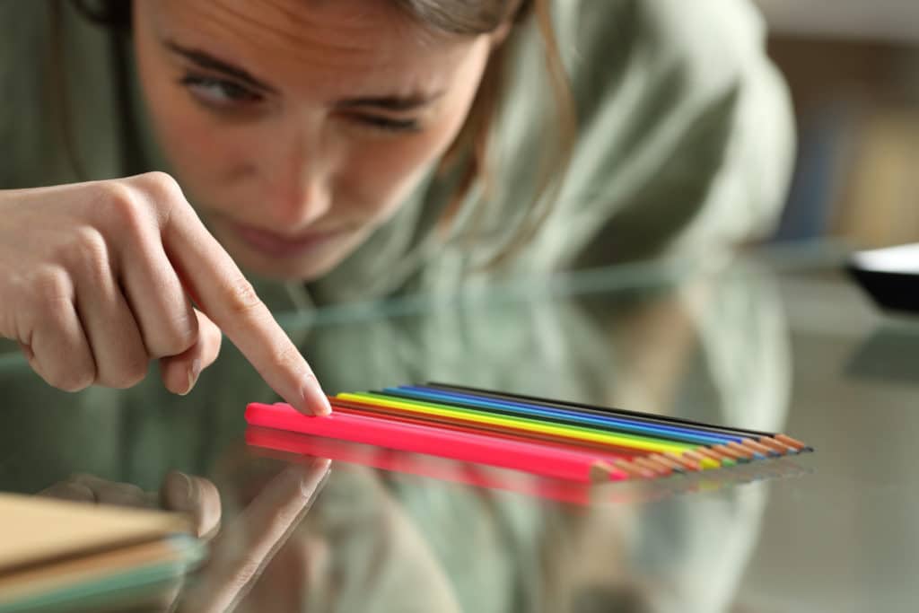 Obsessive,compulsive,woman,aligning,up,pencils,accurately,on,a,glass