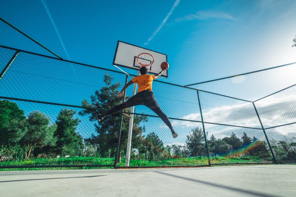 A Guy Throws A Ball Into A Basketball Hoop