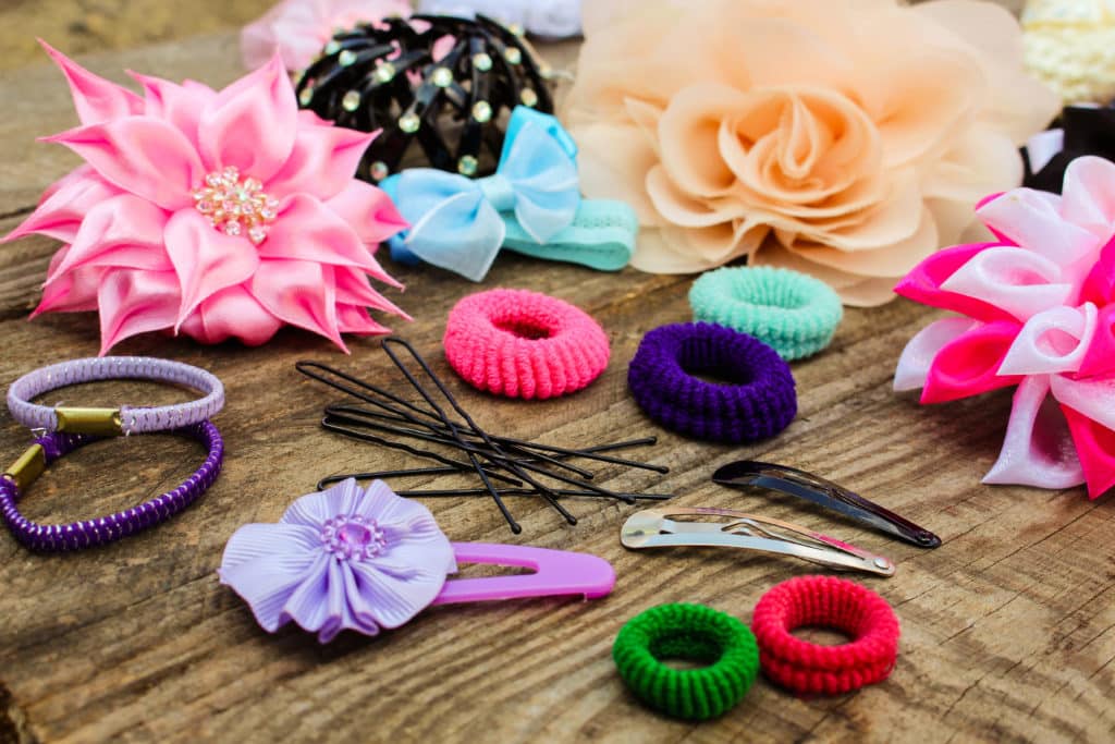Different Hair Clips On Wooden Background