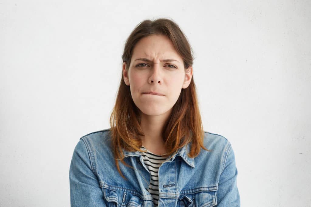 Headshot,of,indecisive,confused,young,european,woman,in,denim,wear