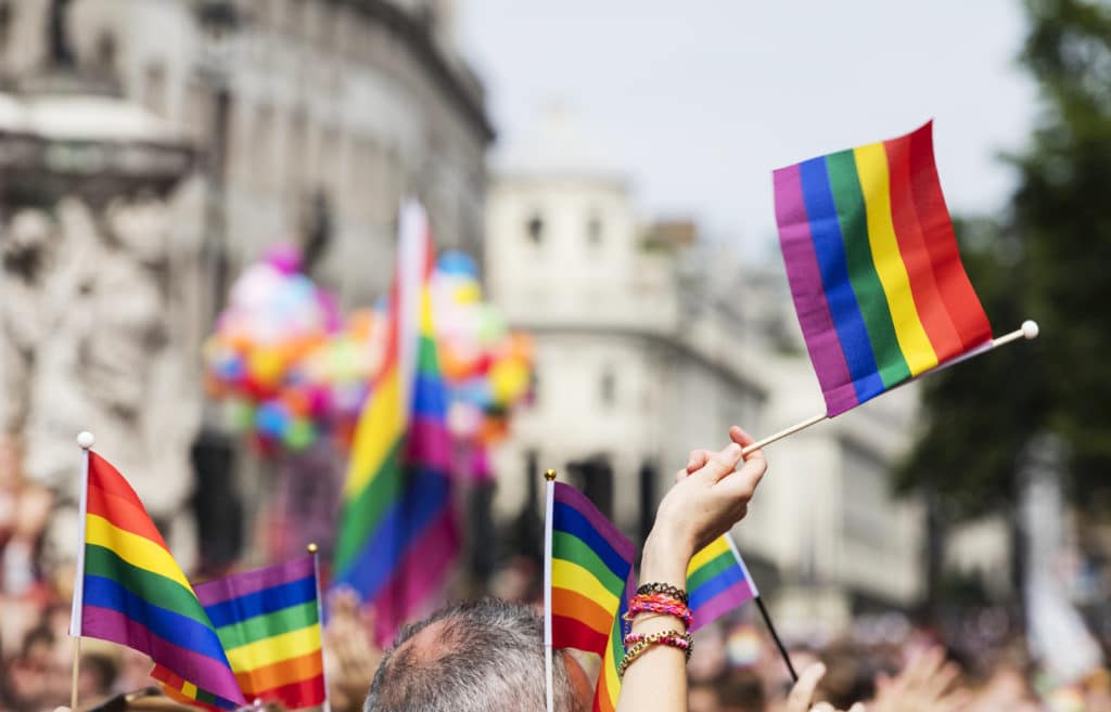 A Spectator Waves A Gay Rainbow Flag At An Lgbt
