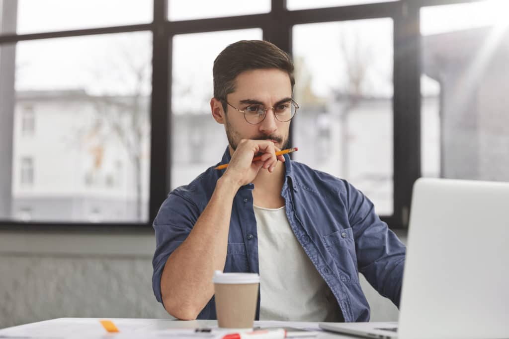 View Of Concentrated Talented Skilled Male Focused On Screen Of