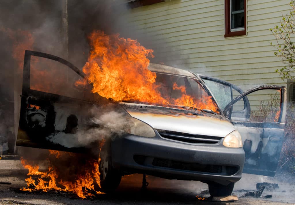 A Closeup View Of A Burning Car. Fire Rages Out