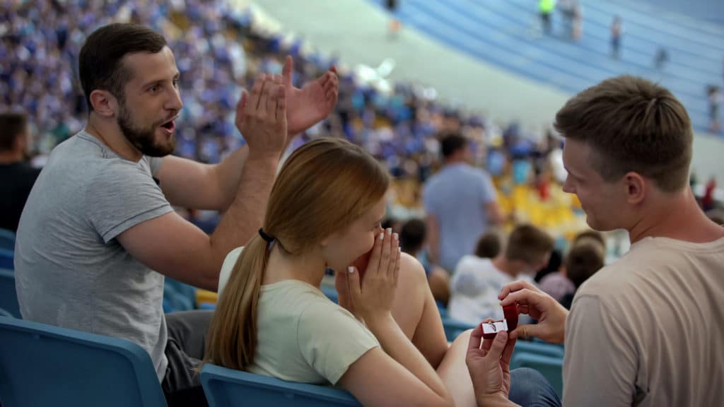 Young Football Fan Making Proposal To Girlfriend At Stadium Romantic
