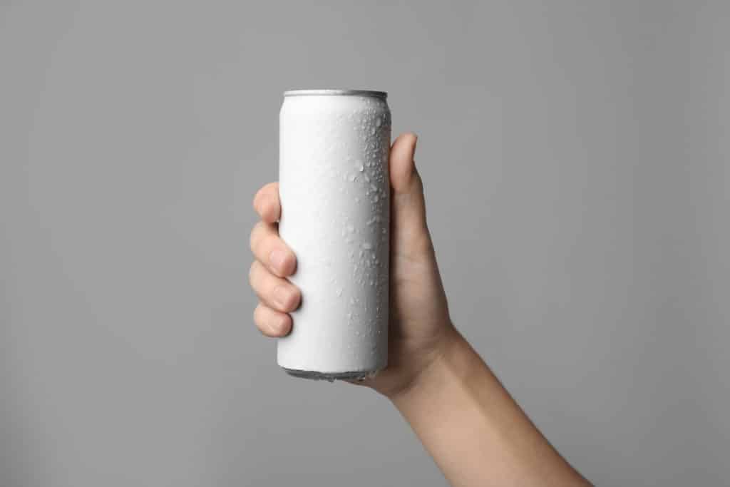 Woman Holding Aluminum Can With Beverage On Grey Background Closeup.