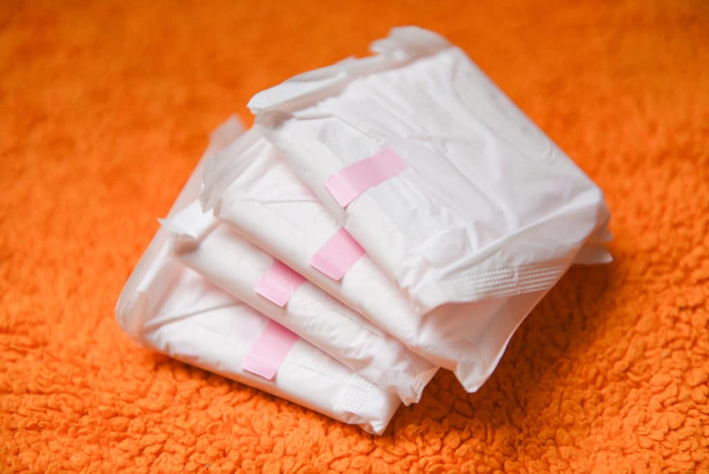 Sanitary Napkin Or Feminine Sanitary Pad On A Orange Knitted