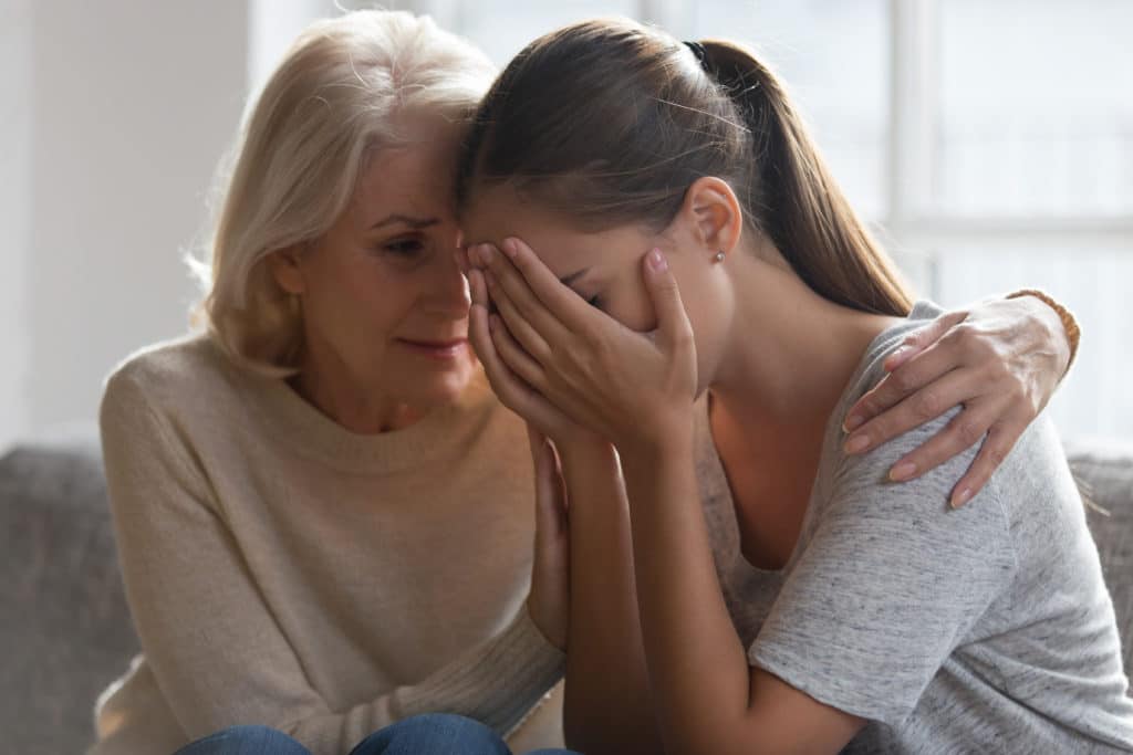 Worried Aged Mother Embracing Comforting Grown Up Daughter With Broken