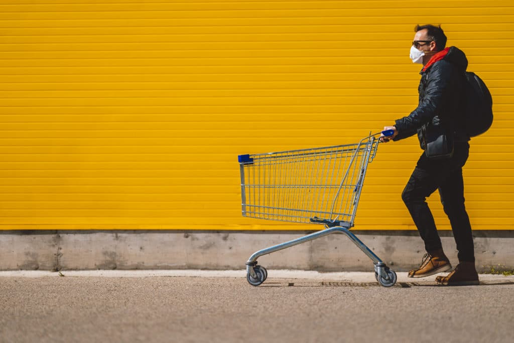 Man With With A Shopping Cart In Front Of A