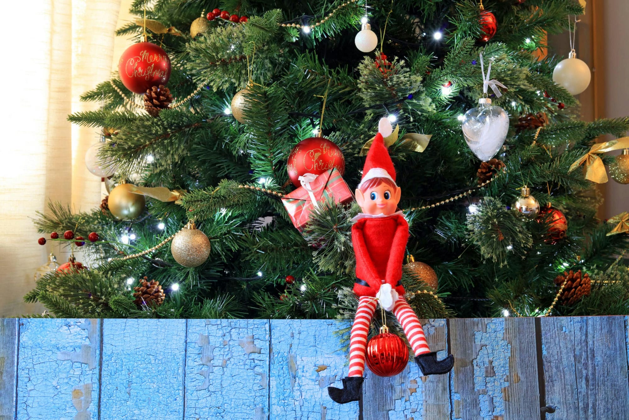 Mischievous Elf On The Shelf Sat On A Christmas Tree