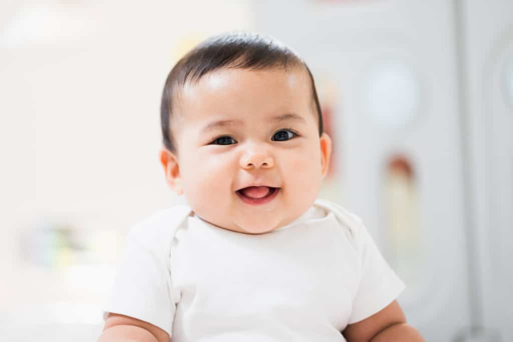 A Cute Baby Wearing A White Dress Stay With Parents