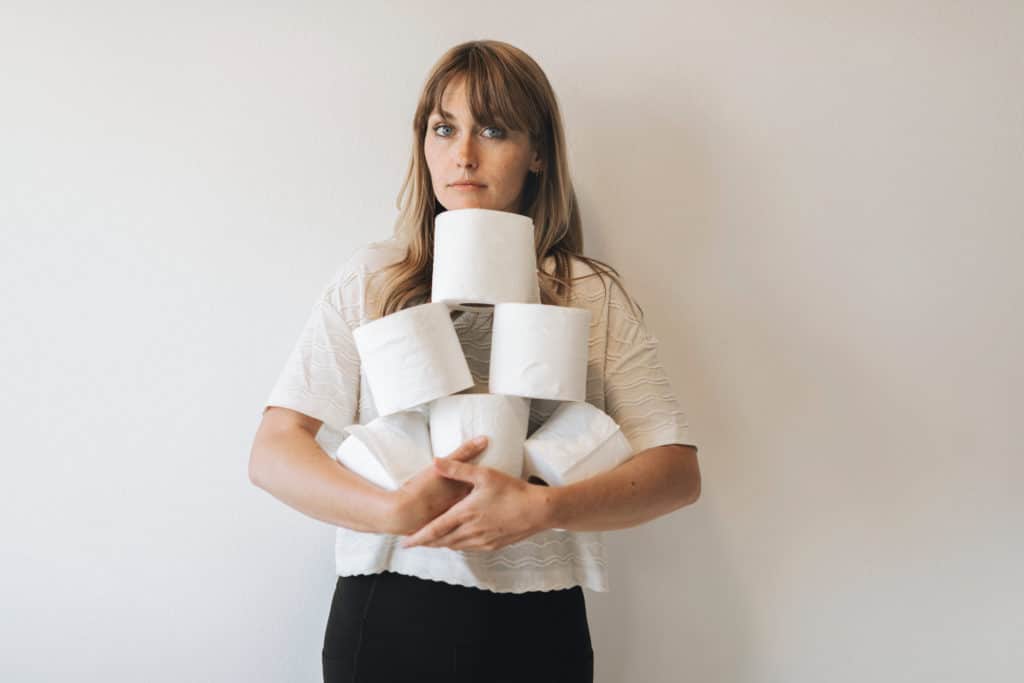 Woman With A Pile Of Toilet Tissue Rolls