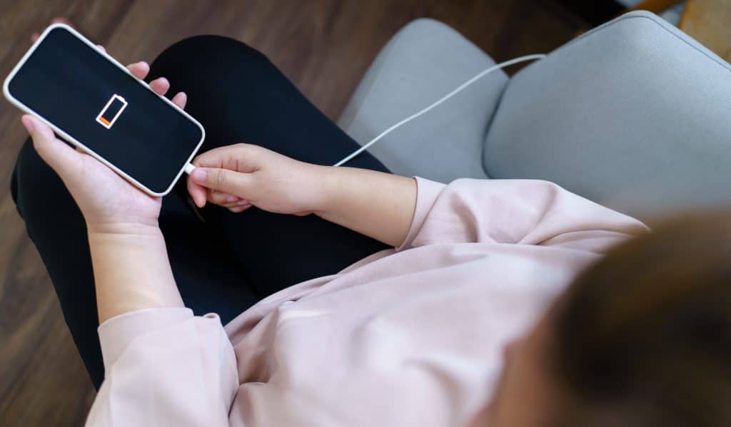 Woman Hands Charging Mobile Phone Battery With Low Battery. Plugging