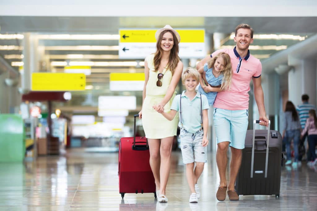Happy Family With Suitcases In The Airport