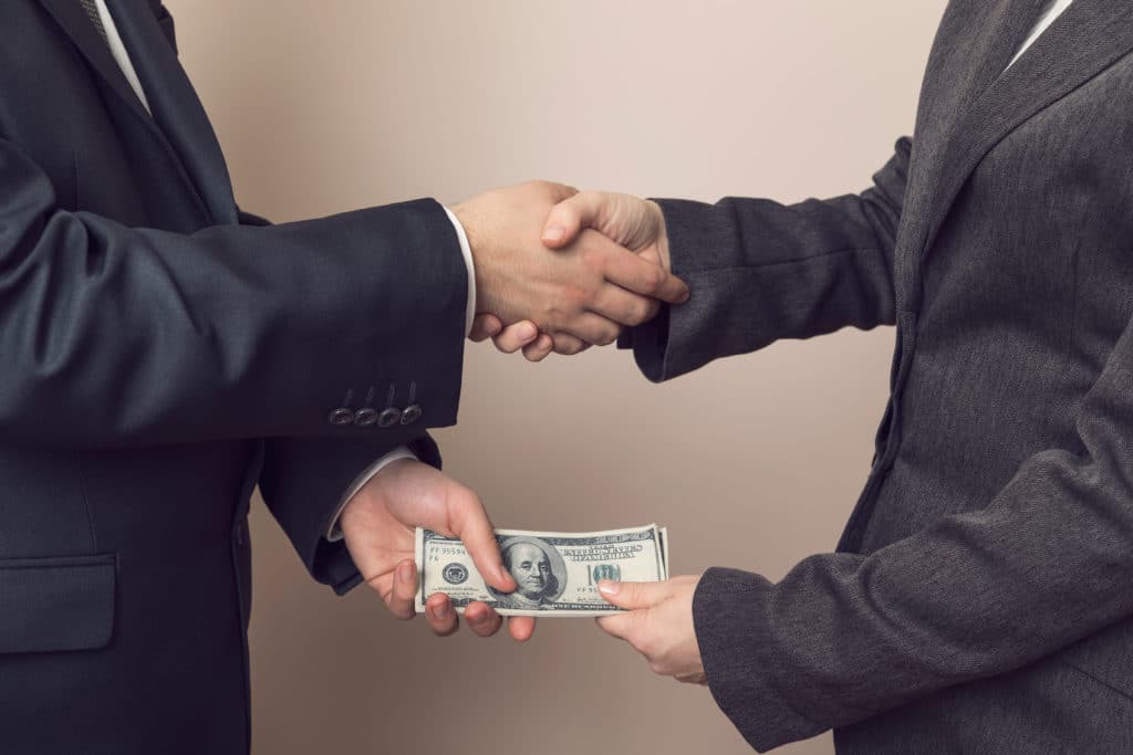 Corrupted Businessman Sealing The Deal With A Handshake And Receiving