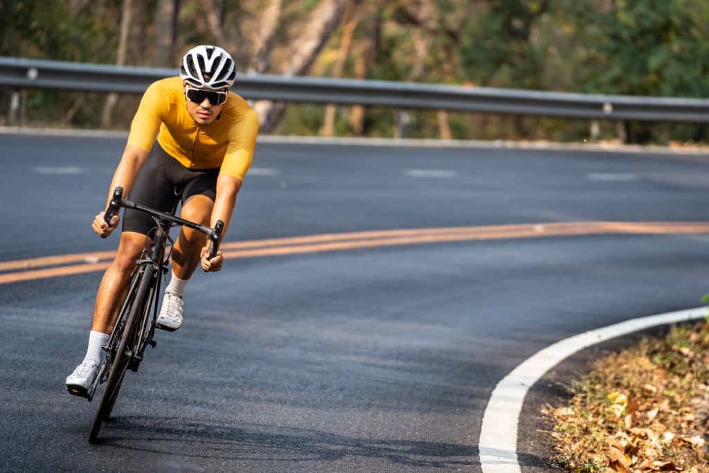 Asian Man In Yellow Cycling Jersey Riding On Road Bike