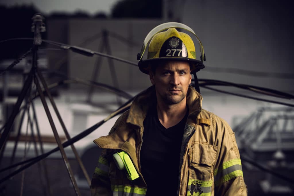 Firefighter With Uniform And Helmet Stand In Front Of Electric