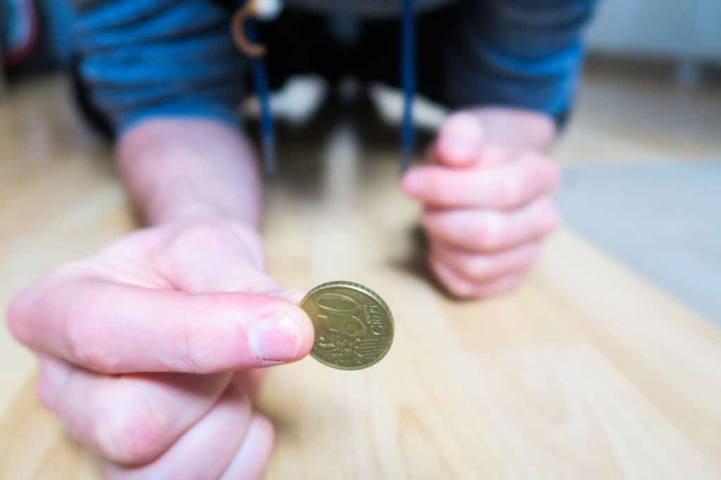 Young Male Hands Picking Up Euro Coins From Wooden Floor
