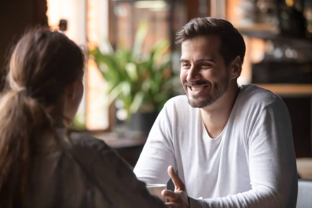 Rear View Woman Sitting At Table In Cafe With Handsome