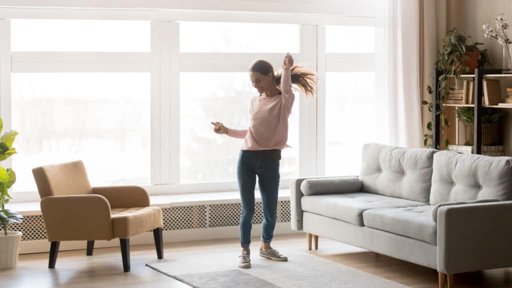 Happy Carefree Young Woman Dancing Alone Having Fun At Home