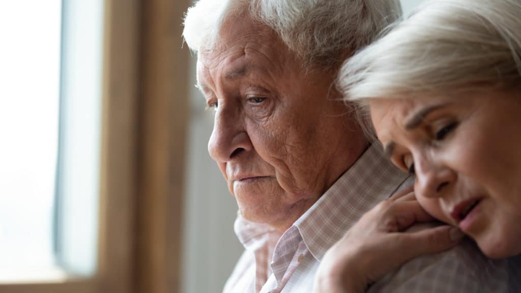 Worried Middle Aged Woman Embracing Upset Old Man From Back 