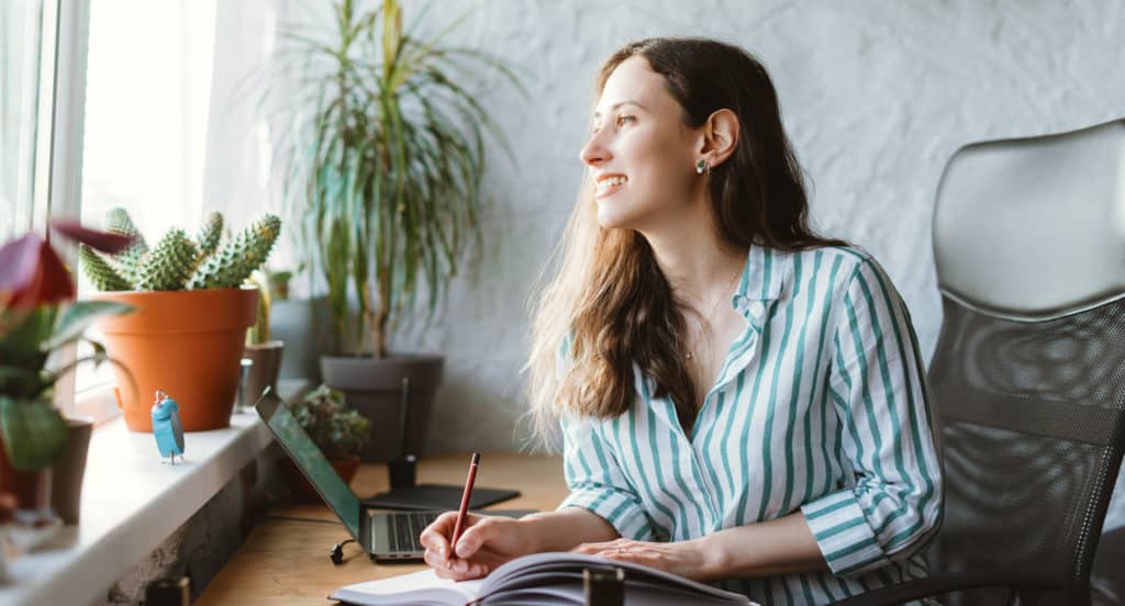 Lovely Young Woman Is Looking Through Window While Writing In