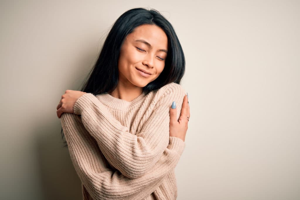 Young Beautiful Chinese Woman Wearing Casual Sweater Over Isolated White