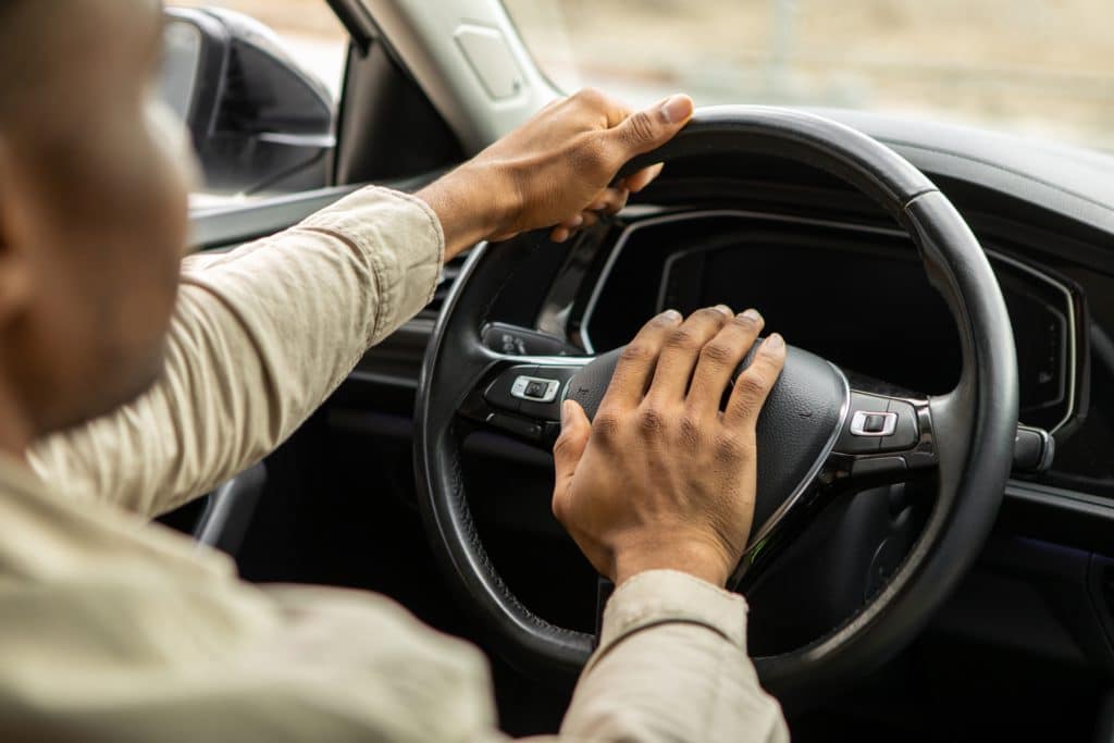 Man Driving A Car With Hand On Horn Button