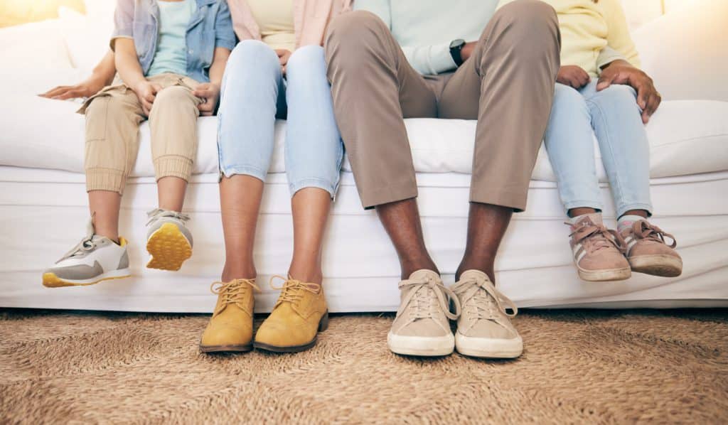 Relax Legs And Shoes Of Black Family On Sofa For
