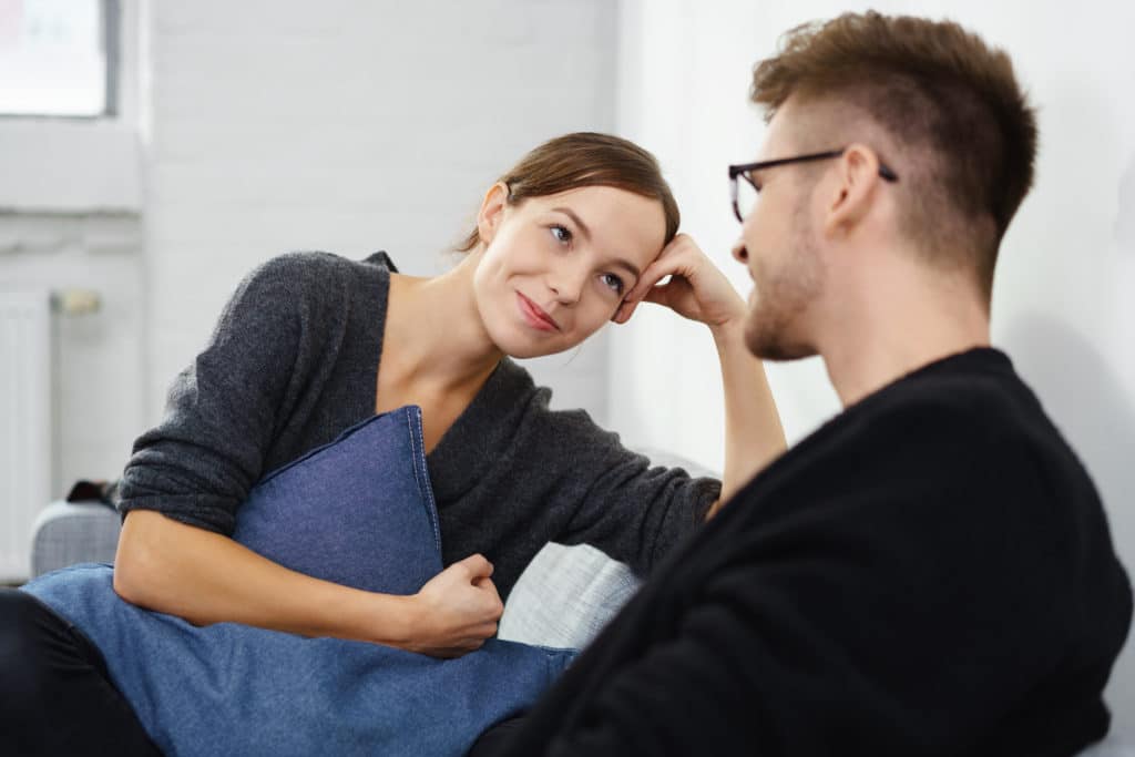 Affectionate Young Couple Relaxing At Home Sitting On The Sofa