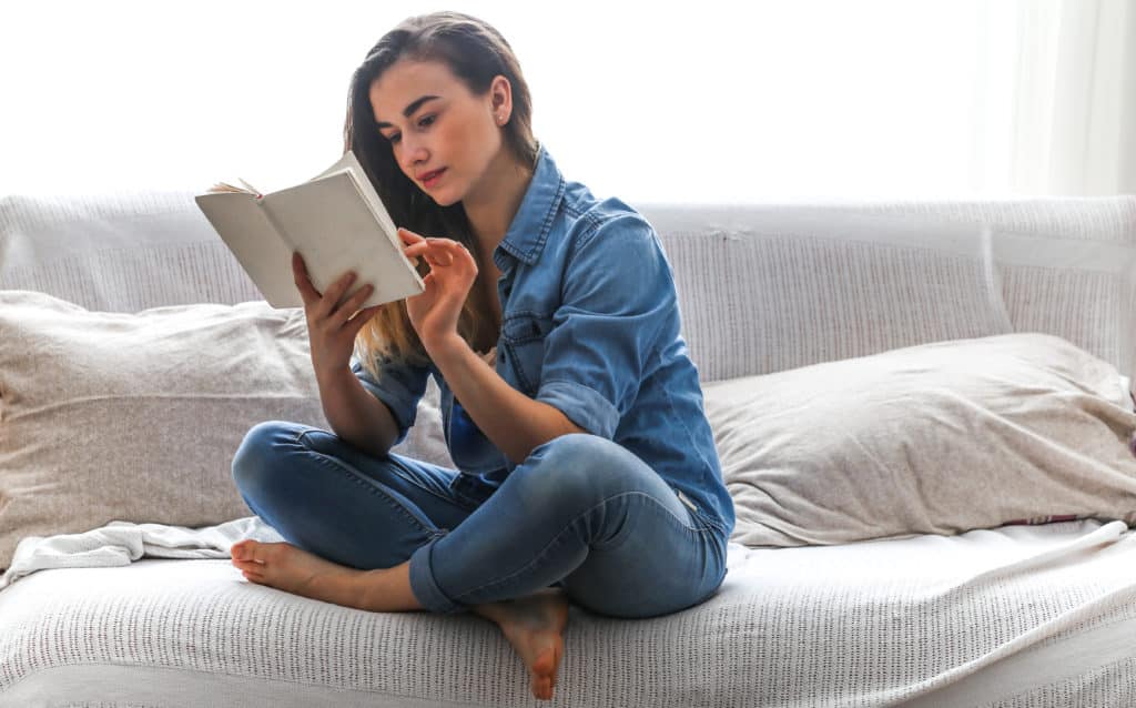 White Cozy Bed And A Beautiful Girl Reading A Book 